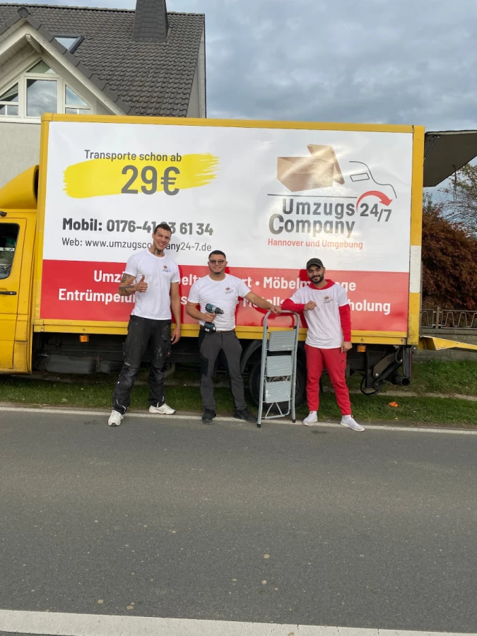 Team von UmzugsCompany24/7 vor gelbem Umzugslaster